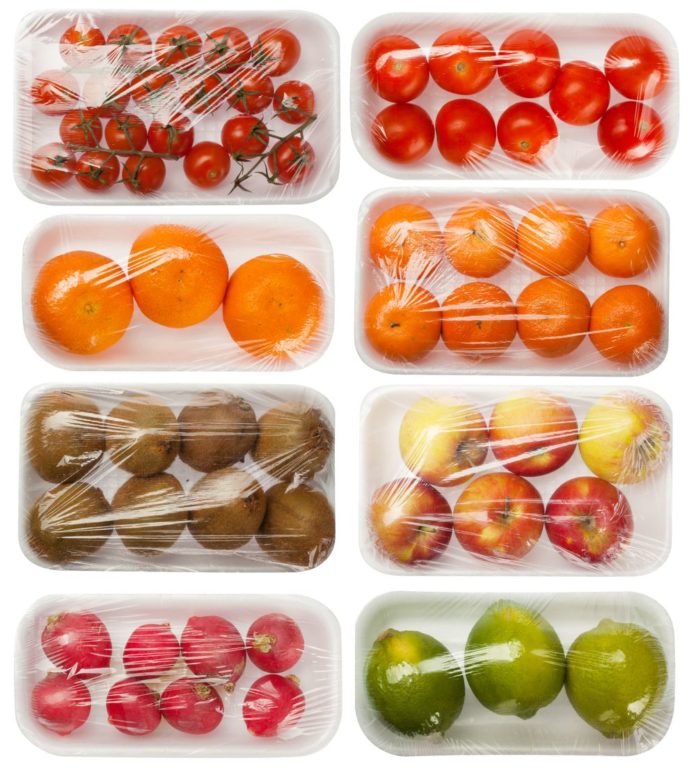 vaisiai ir daržovės vakuuminėje pakuotėje baltame fone